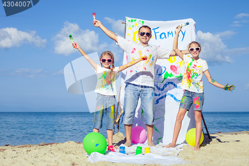 Image of Father and children playing on the beach at the day time.