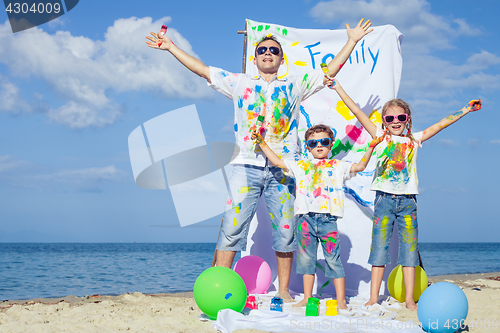 Image of Father and children playing on the beach at the day time.