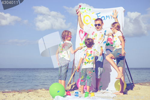 Image of Father and children playing on the beach at the day time.