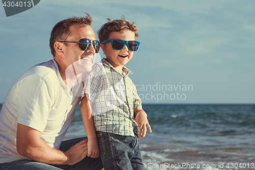 Image of Father and son playing on the beach at the day time.