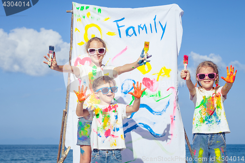 Image of Two sisters and brother playing on the beach at the day time.