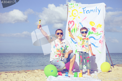 Image of Father and son playing on the beach at the day time.