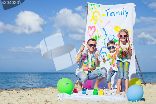 Image of Father and children playing on the beach at the day time.