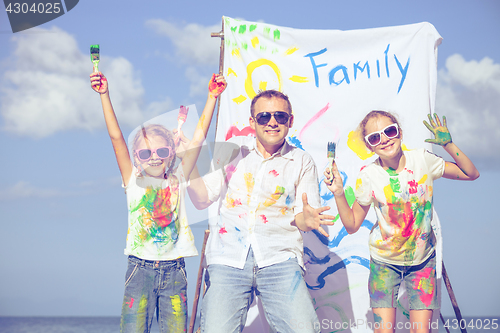 Image of Father and children playing on the beach at the day time.