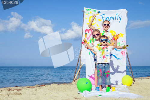 Image of Two sisters and brother playing on the beach at the day time.