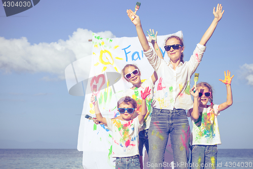 Image of Mother and children playing on the beach at the day time.