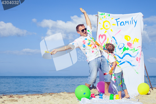 Image of Father and son playing on the beach at the day time.