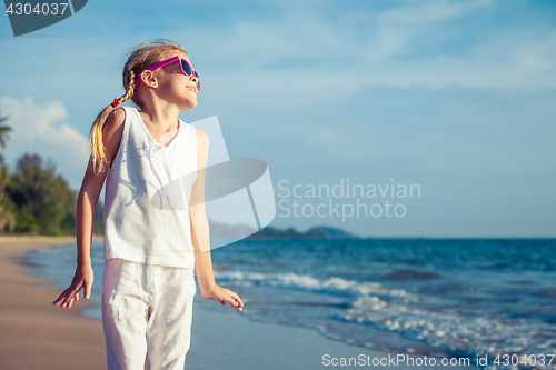 Image of Little girl  dancing on the beach at the day time.