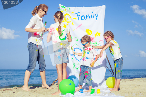 Image of Mother and children playing on the beach at the day time.