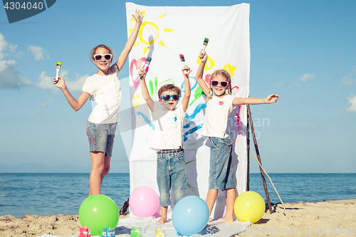 Image of Two sisters and brother playing on the beach at the day time.