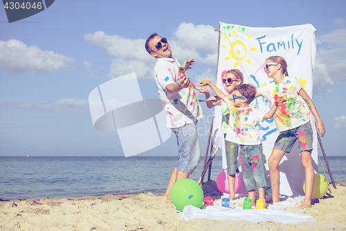 Image of Father and children playing on the beach at the day time.