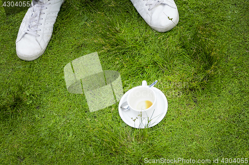 Image of an empty cup of coffee in the grass