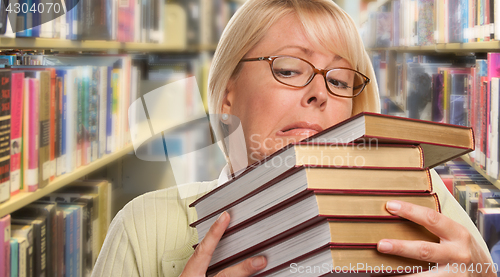 Image of Beautiful Expressive Student or Teacher with Books in Library.