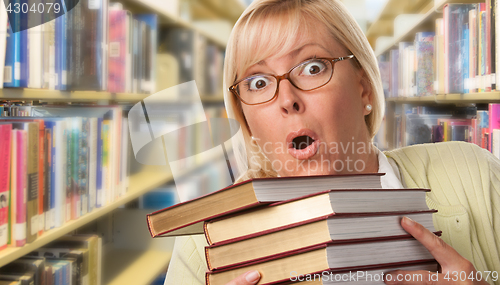 Image of Beautiful Expressive Student or Teacher with Books in Library.