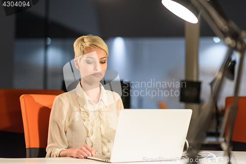 Image of woman working on laptop in night startup office