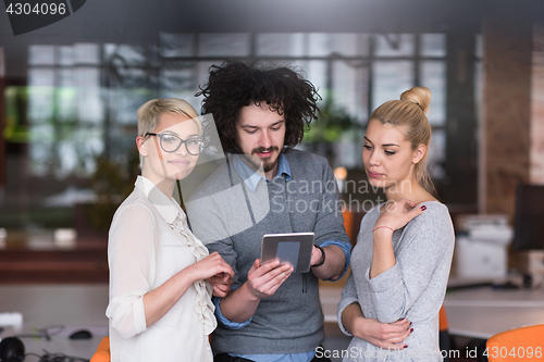 Image of group of Business People Working With Tablet in startup office