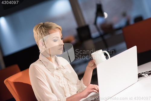 Image of woman working on laptop in night startup office