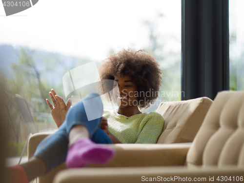 Image of young african american woman at home using digital tablet