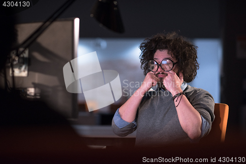 Image of man working on computer in dark startup office