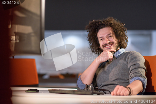 Image of man working on computer in dark startup office