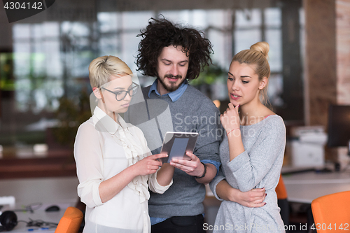 Image of group of Business People Working With Tablet in startup office