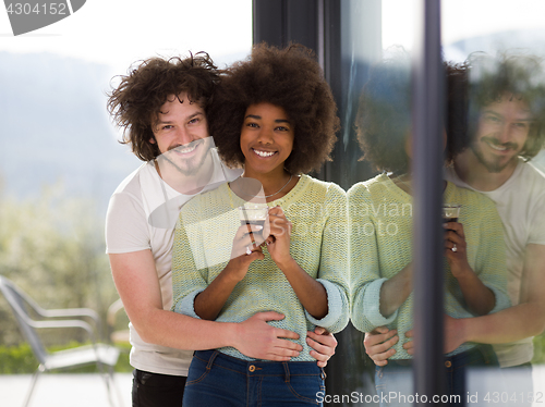 Image of happy multiethnic couple relaxing at modern home indoors