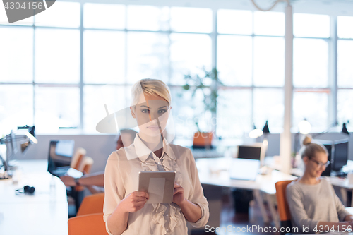 Image of woman working on digital tablet in night office