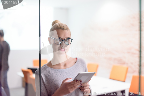 Image of woman working on digital tablet in night office