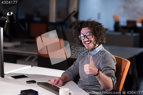 Image of man working on computer in dark startup office