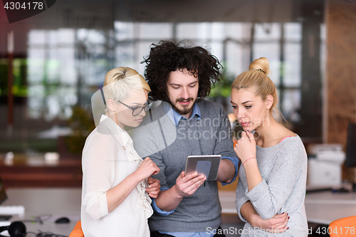 Image of group of Business People Working With Tablet in startup office