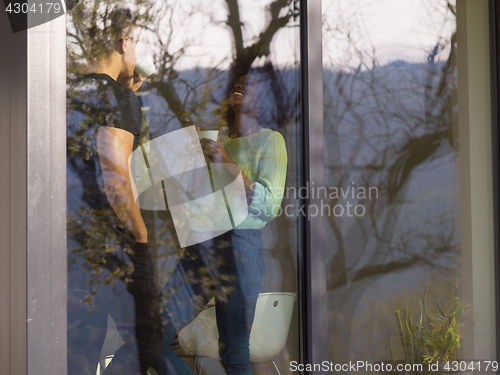 Image of happy multiethnic couple relaxing at modern home indoors
