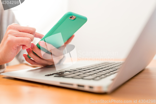 Image of Using cellphone and laptop computer