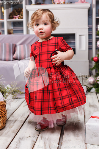 Image of Little girl standing at studio with christmas decorations