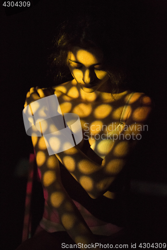 Image of The body of woman with color pattern in the beam projector