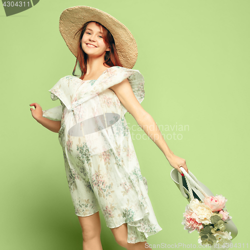 Image of Young beautiful pregnant woman standing on blue background