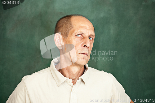 Image of Worried mature man sitting at studio