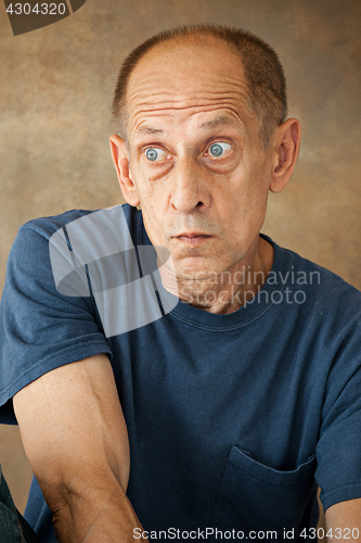 Image of Worried mature man sitting at studio