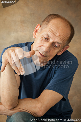 Image of Worried mature man sitting at studio