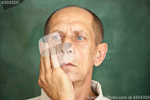 Image of Worried mature man touching his head.