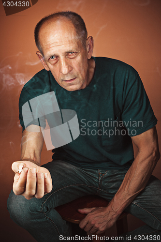 Image of Worried mature man sitting at studio