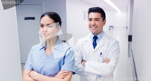 Image of smiling doctor in white coat and nurse at hospital