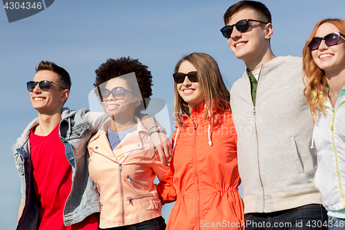 Image of happy teenage friends in shades talking on street