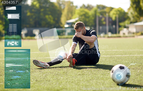 Image of injured soccer player with ball on football field