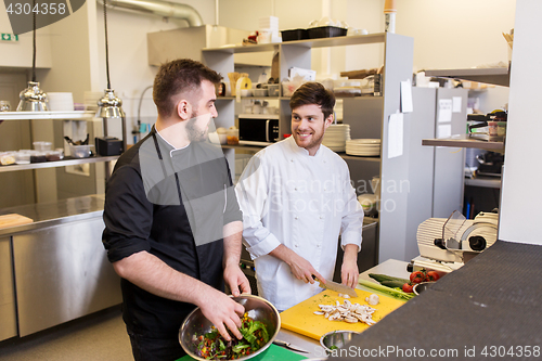 Image of chef and cook cooking food at restaurant kitchen