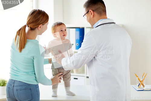 Image of happy woman with baby and doctor at clinic