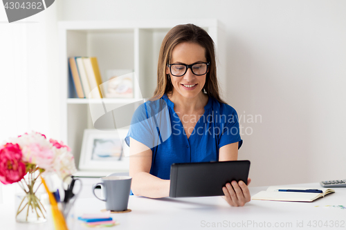 Image of woman with tablet pc working at home or office