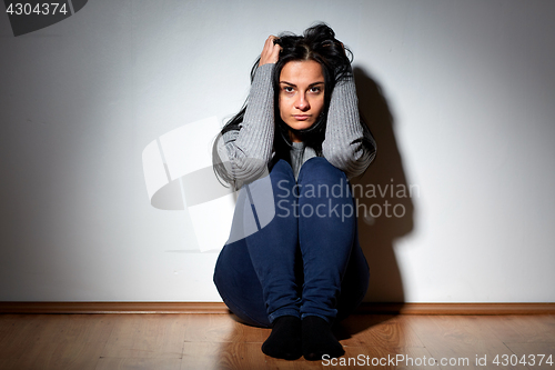 Image of unhappy woman crying on floor at home