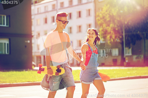 Image of teenage couple with skateboards on city street