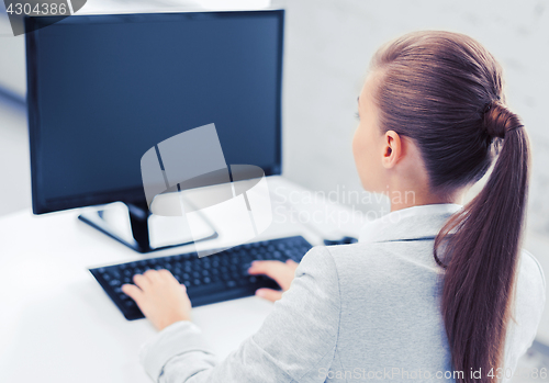 Image of businesswoman with computer in office