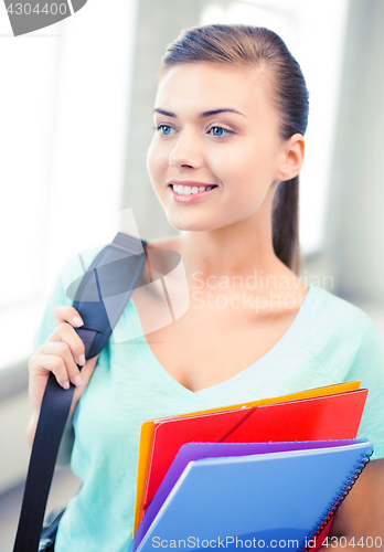 Image of student girl with school bag and color folders